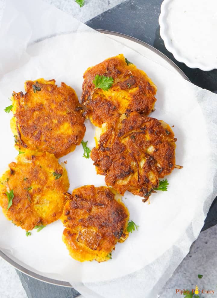 Chickpea and squash fritters on a white serving plate.