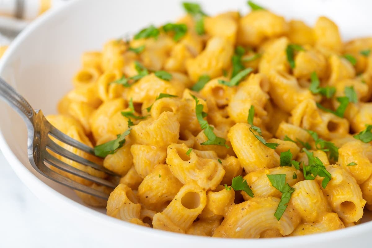 Butternut squash mac and cheese topped with fresh parsley.
