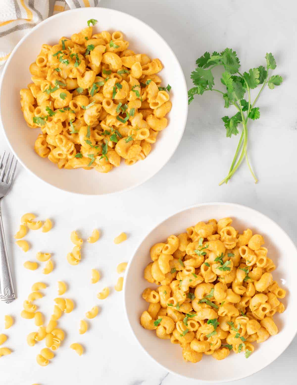 Overhead of vegan butternut squash mac and cheese in white bowls.