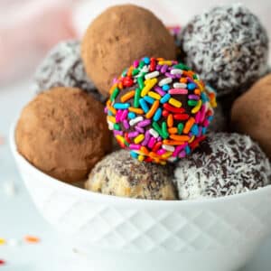 Vegan chocolate truffles coated in coca powder, coconut, nuts, and sprinkles.