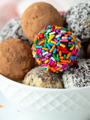 Vegan chocolate truffles coated in coca powder, coconut, nuts, and sprinkles.