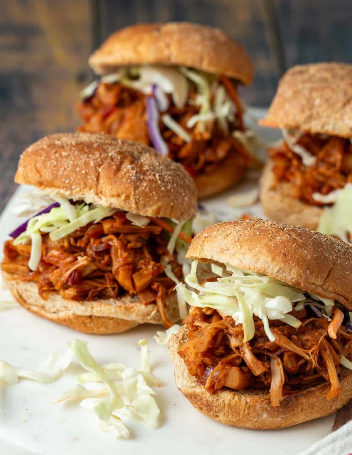 Vegan pulled pork sandwiches on a serving tray.

