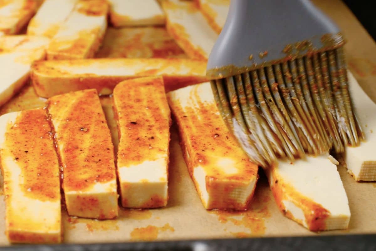 Brushing tofu slices with spice mixture.
