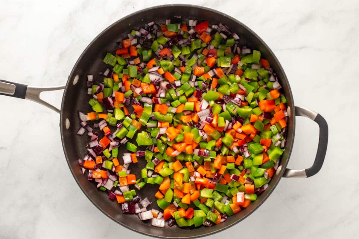Diced peppers and onions in a saute pan.
