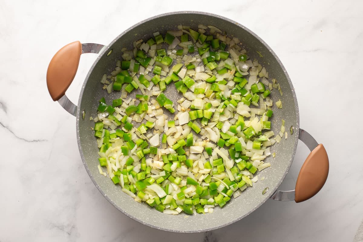 Sauted onions, green peppers, and garlic in a saute pan.