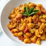 Vegan hamburger helper in a wide white bowl topped with parsley.