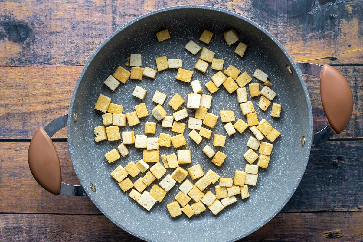 Cubed tofu in saute pan.