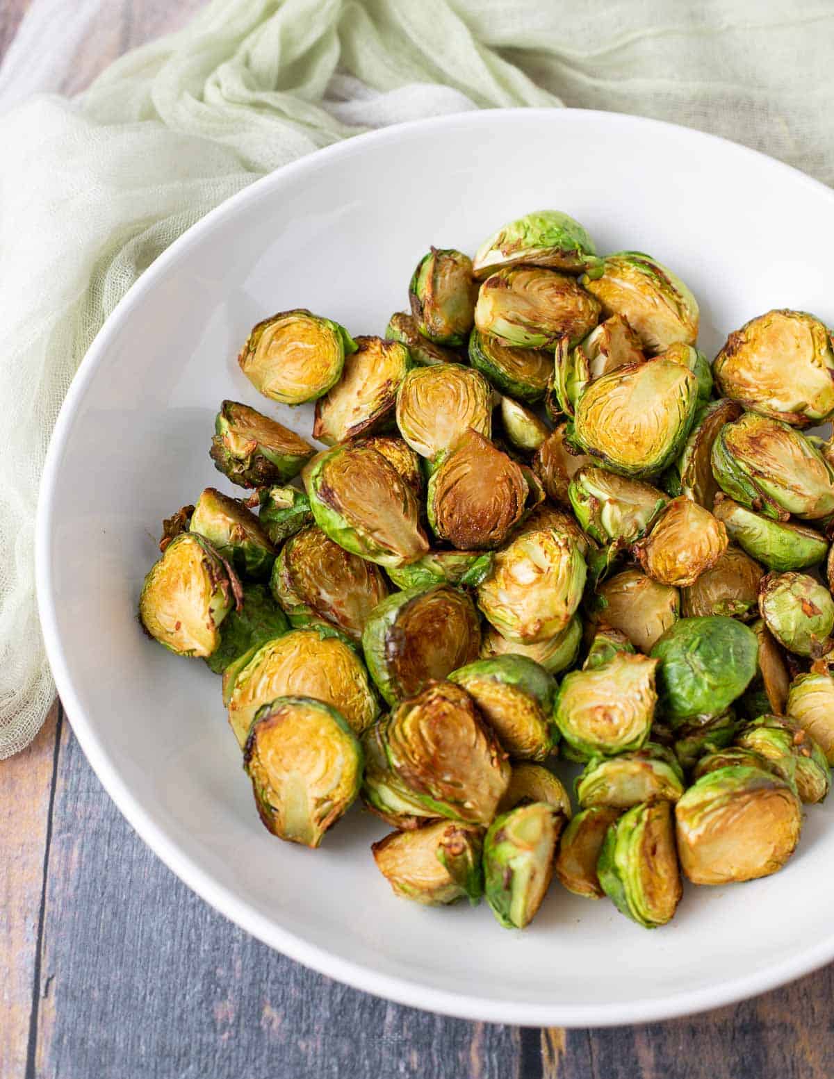 Soy-glazed Brussels sprouts in a white serving bowl. 