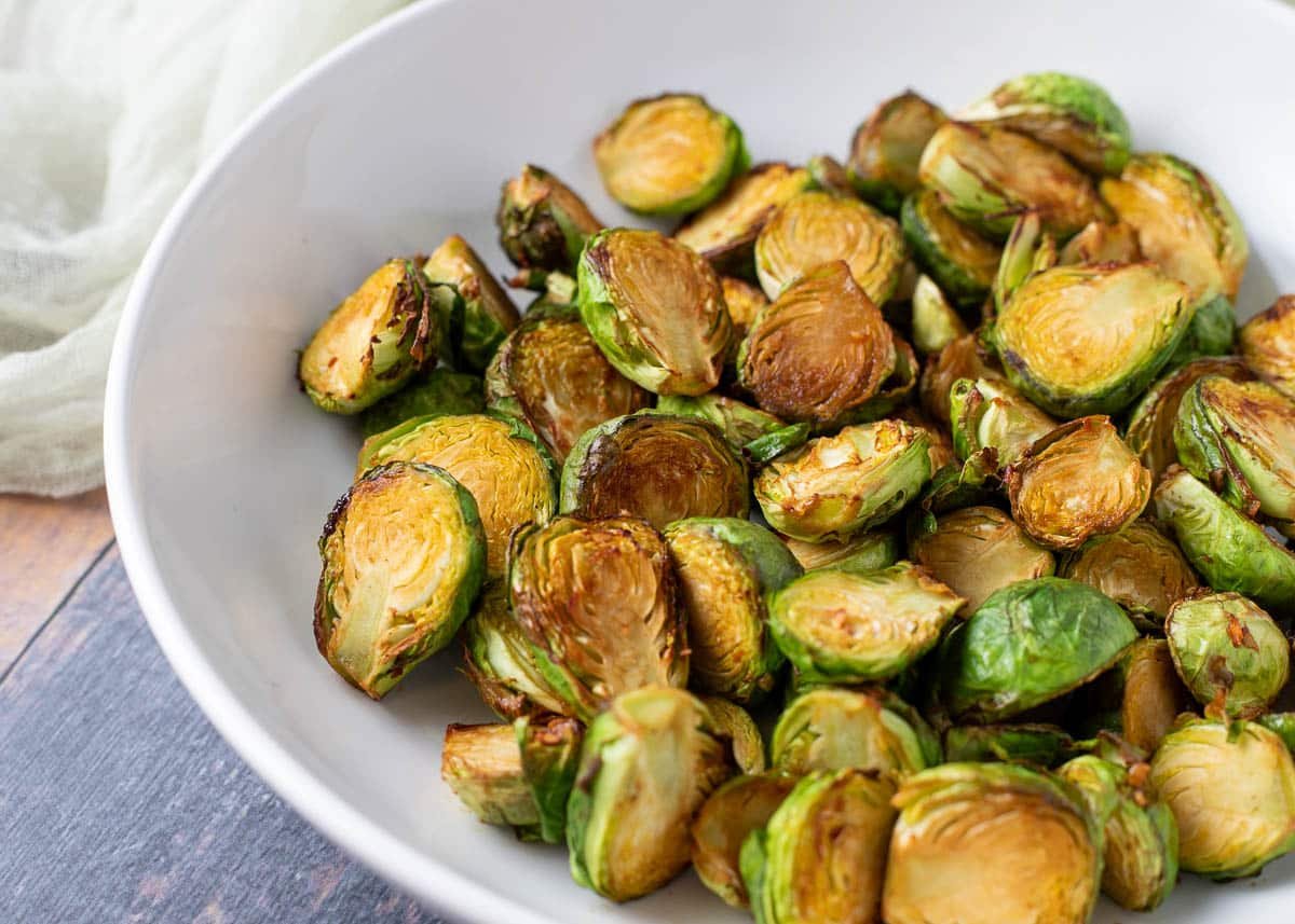 Soy glazed brussels sprouts in white bowl.