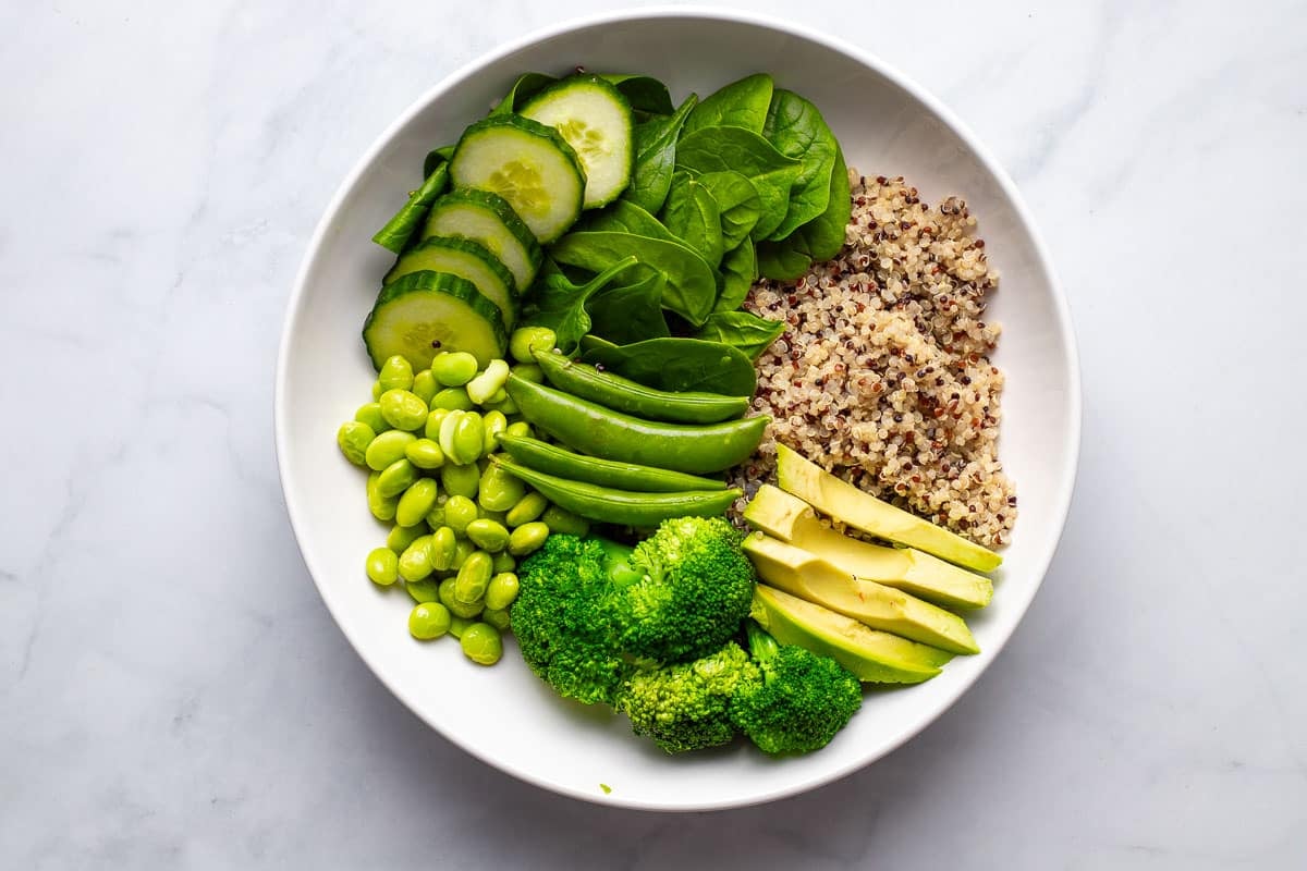 Green vegetables arranged in a bowl with quinoa.