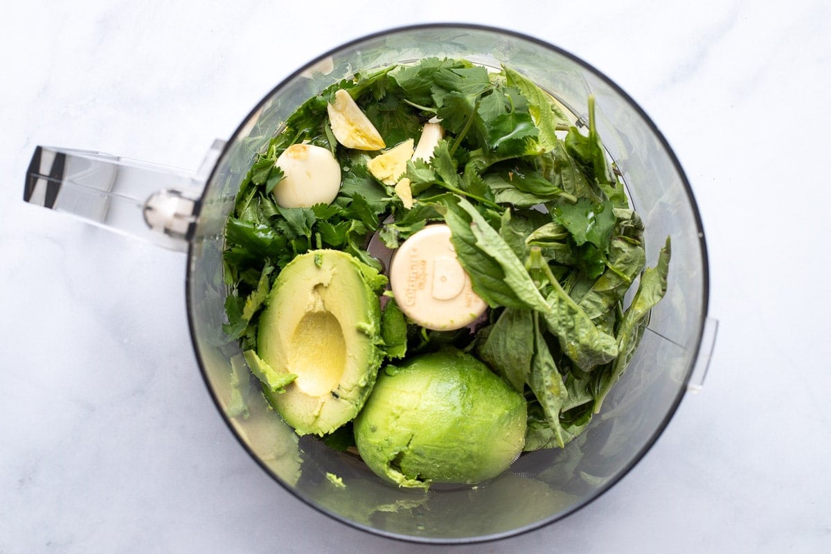 Green goddess ingredients in a food processor.