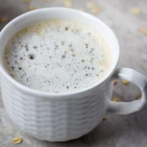 Plain oat milk latte in a small white cup.