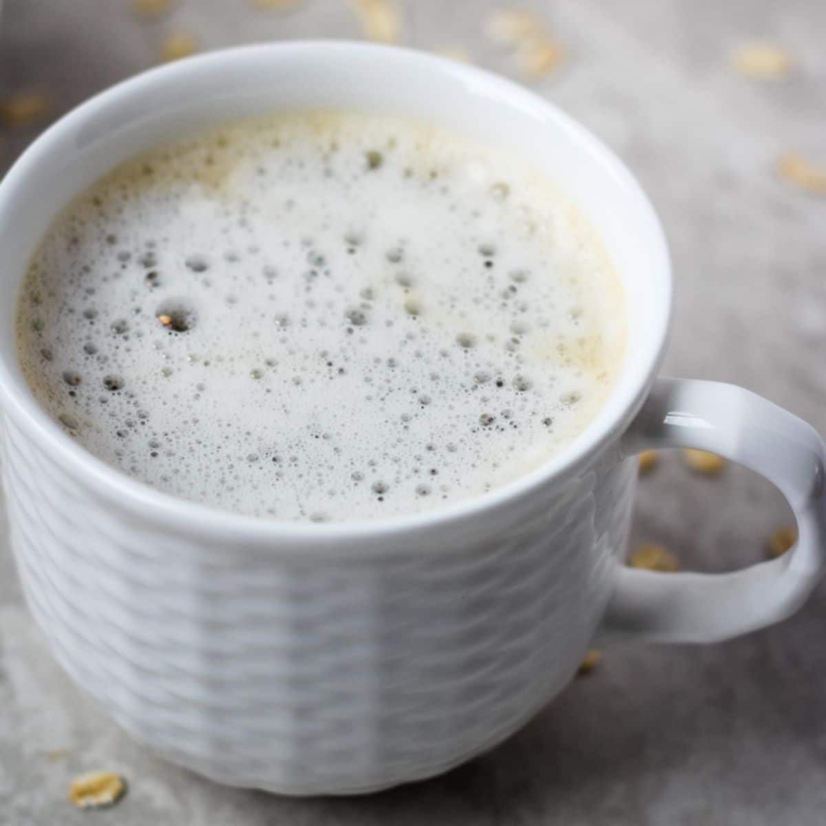 Plain oat milk latte in a small white cup.