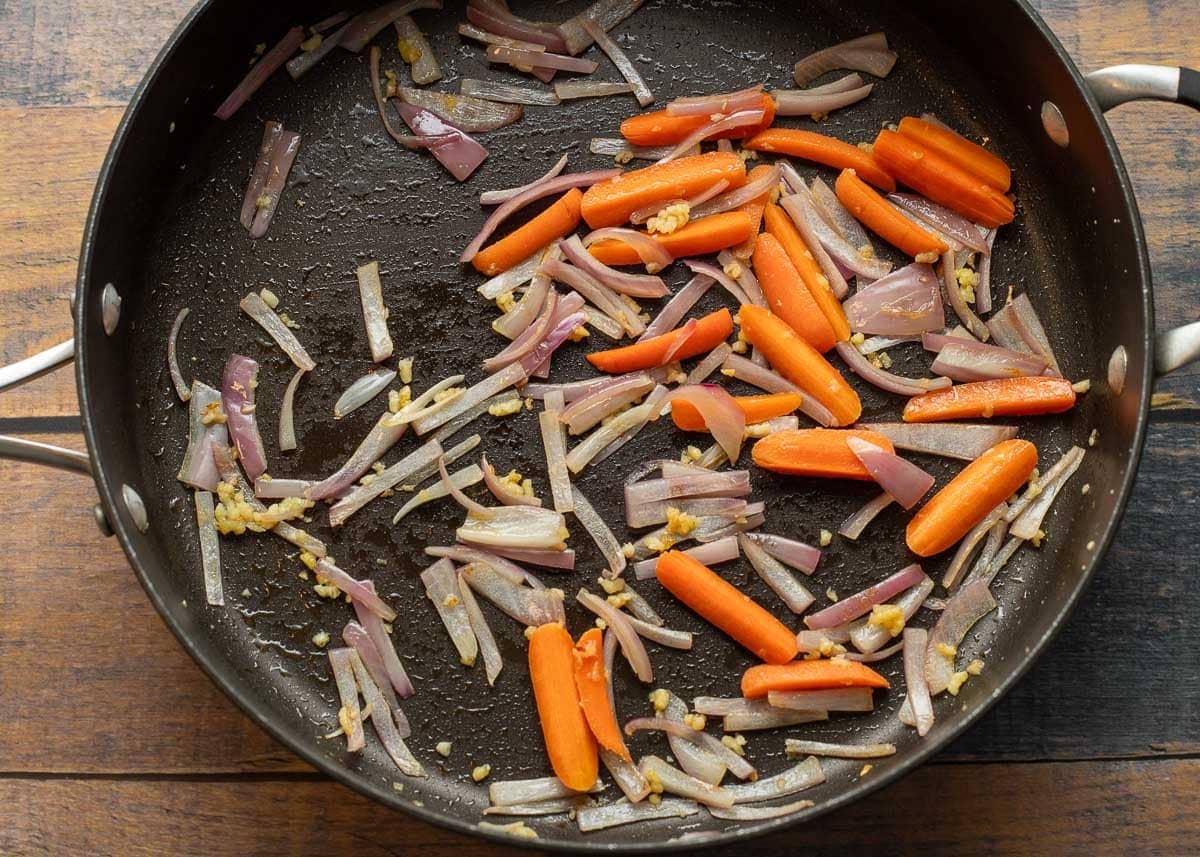 Sauted garlic, onions, and carrots in pan.