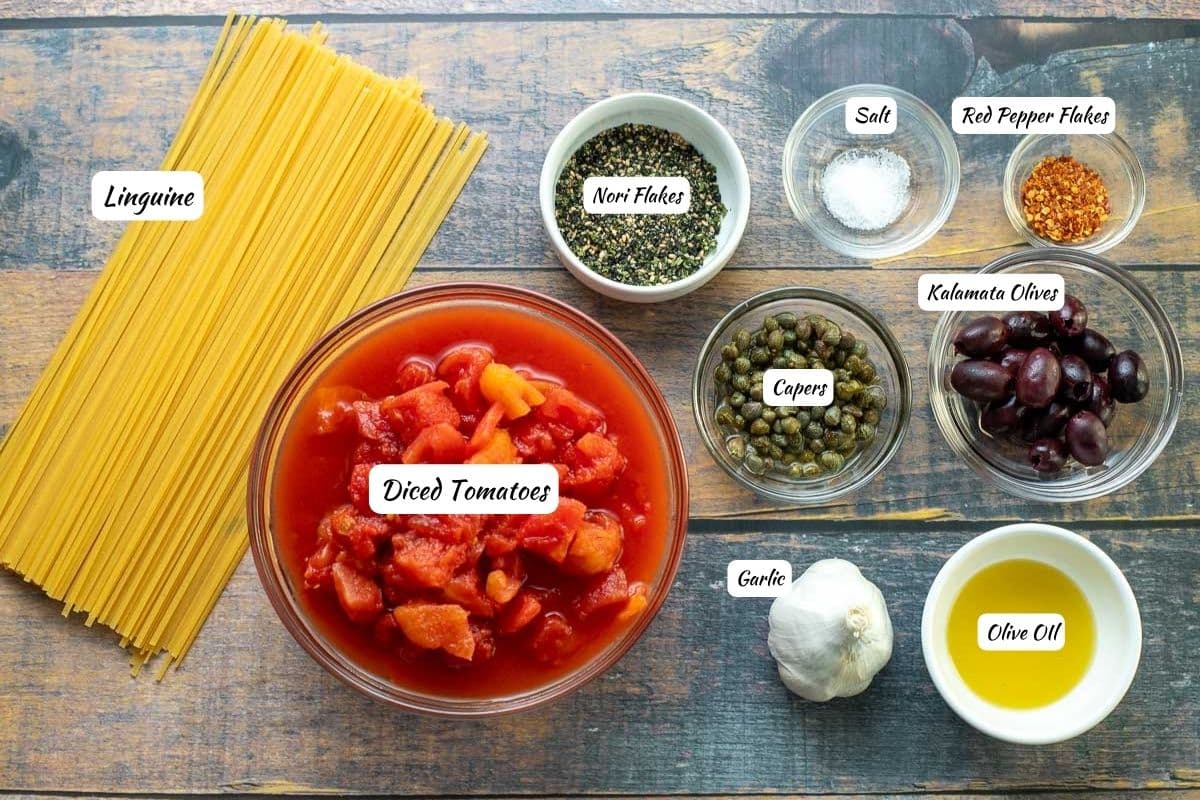 Pasta puttanesca ingredients: linguine, diced tomatoes, garlic, olive oil, kalamata olives, capers, nori flakes, salt, red pepper flakes.