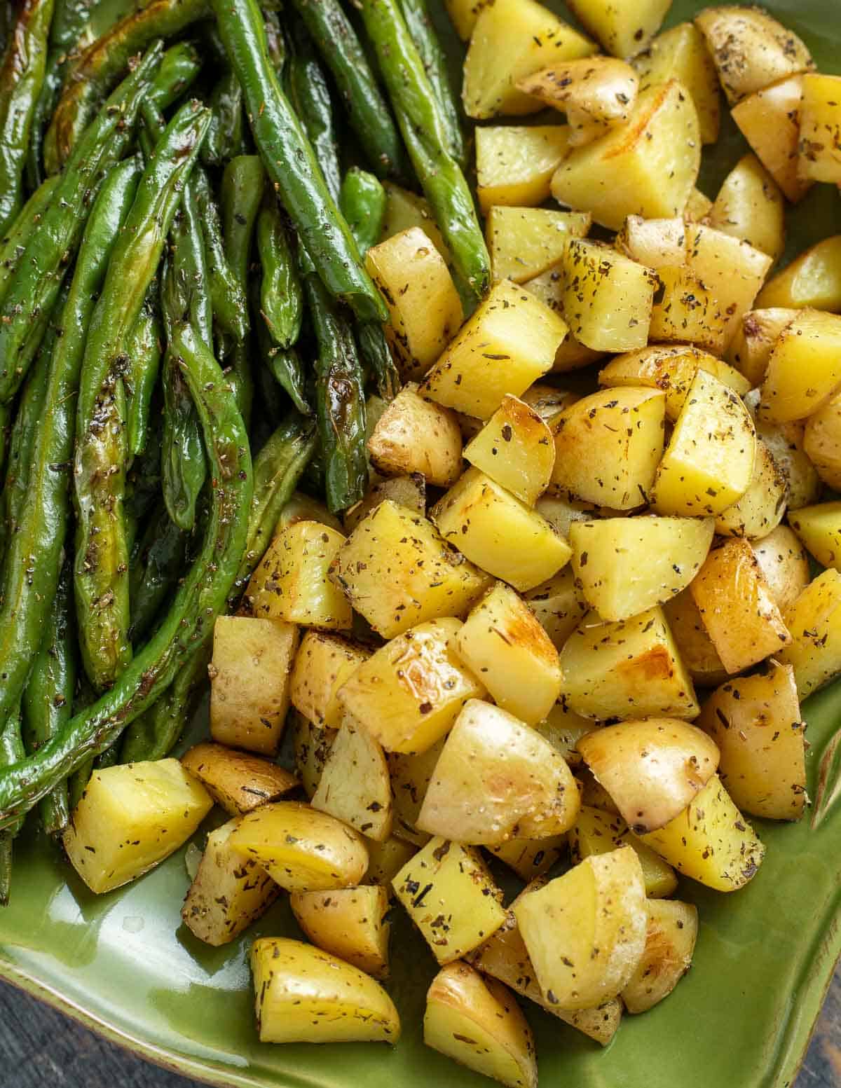 Close up of green beans and potatoes on green platter.