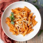 Penne pasta coated with vegan vodka sauce topped with fresh basil and vegan parmesan cheese.