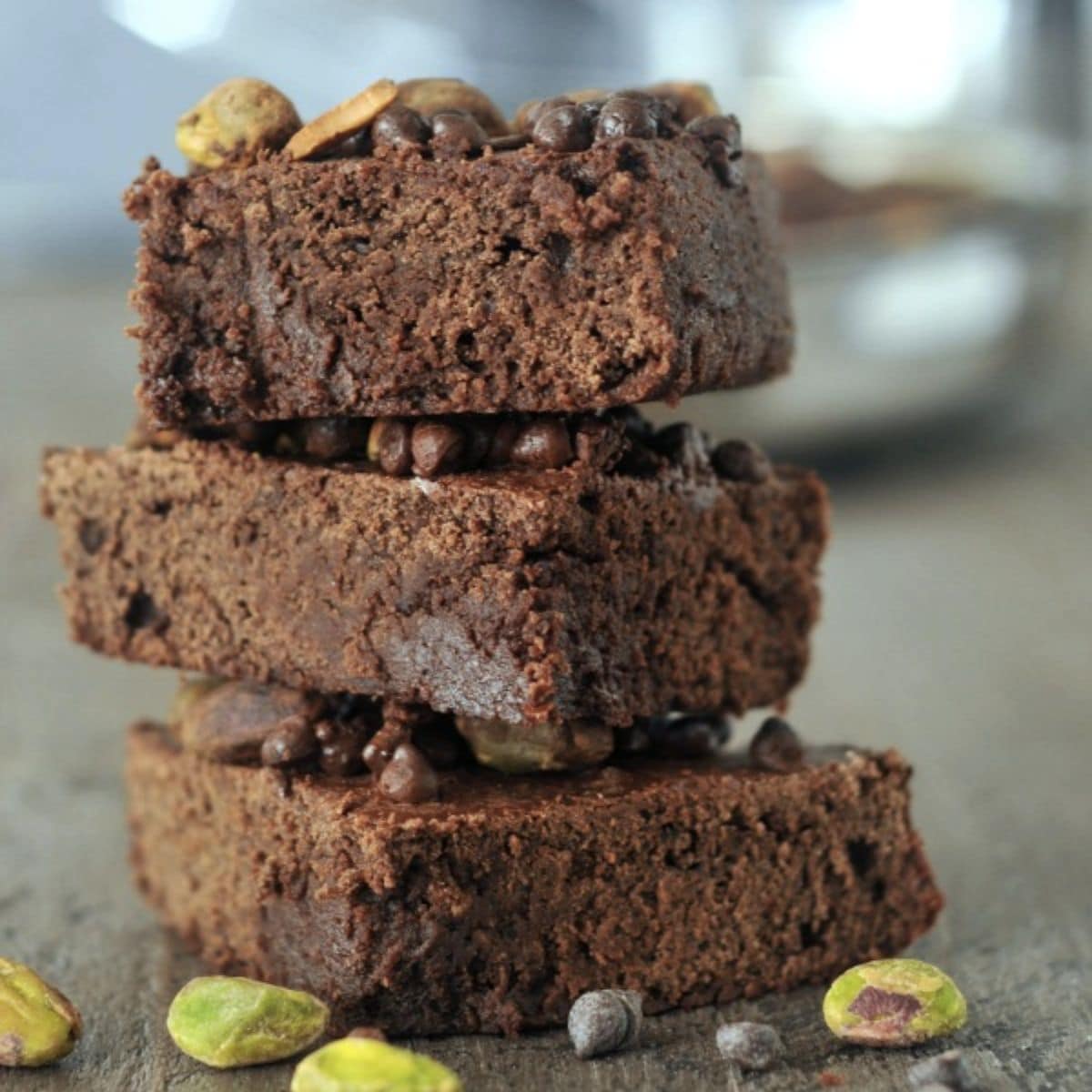 Stalk of vegan air fryer brownies with chocolate chips and pistachios.