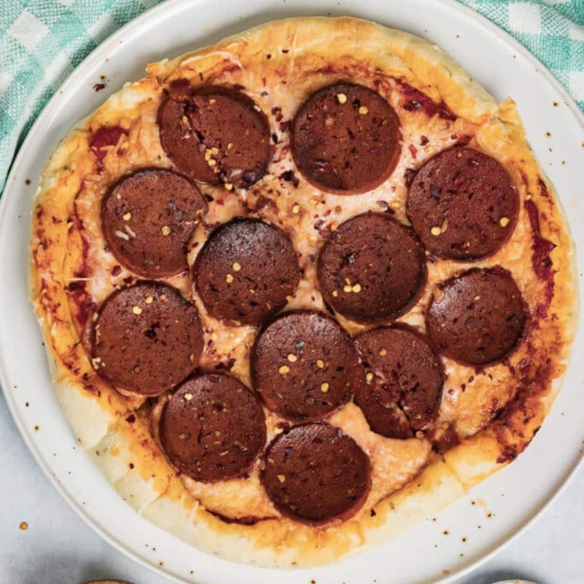 Vegan pepperoni pizza on a white plate.