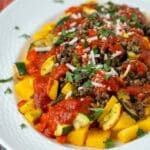 Crispy baked polenta cubes topped with roasted vegetables, lentils, marinara sauce, cheese, and parsley.