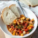 Bowl of ratatouille served with two slices of sourdough bread.
