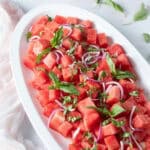 Watermelon basil salad topped with red onion.