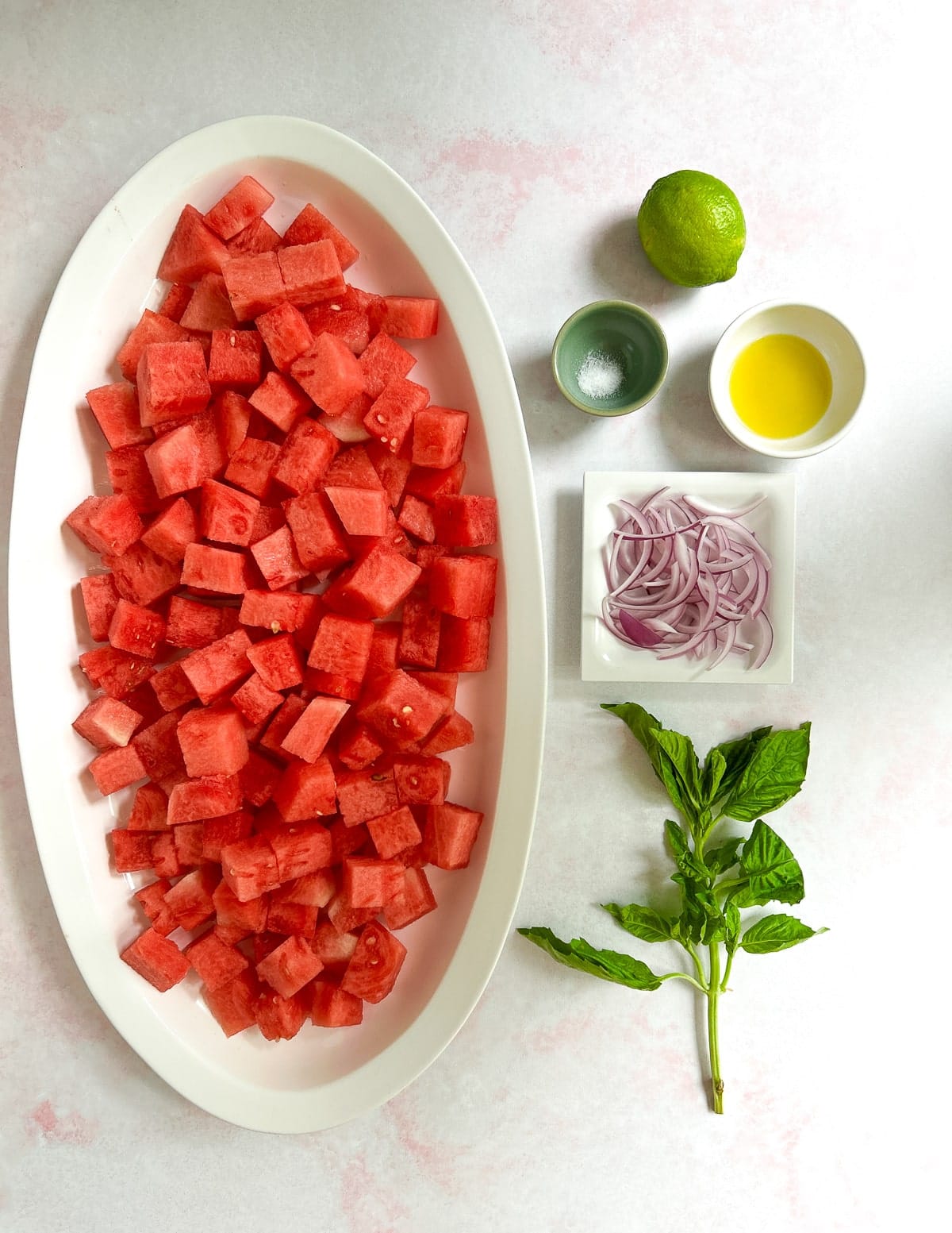 Watermelon cut into cubes, lime, salt, olive oil, red onion, basil. 