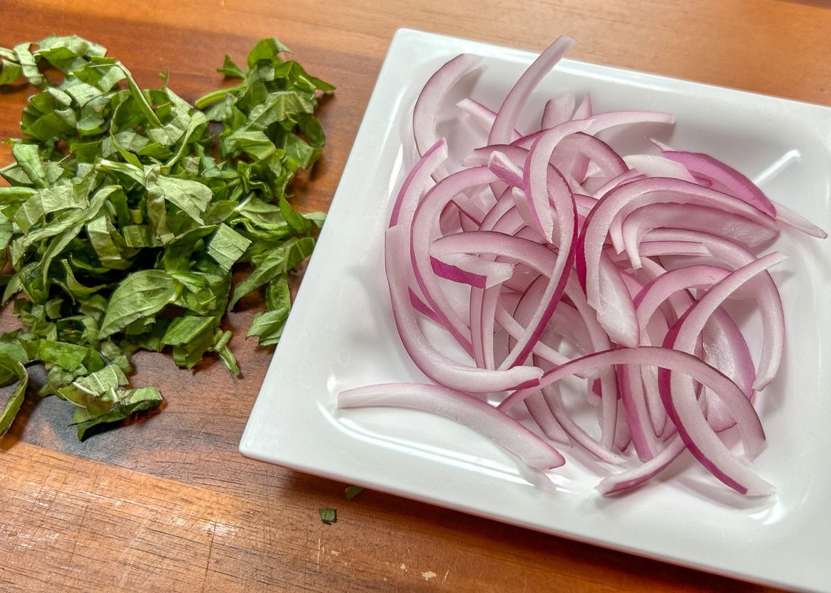 Basil cut into strips, and red onion sliced thin. 