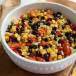 Charred corn salad with black beans in a white serving bowl.