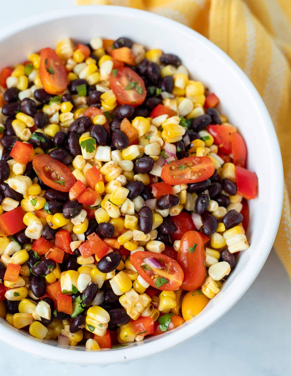 Charred corn salad in a white serving bowl.