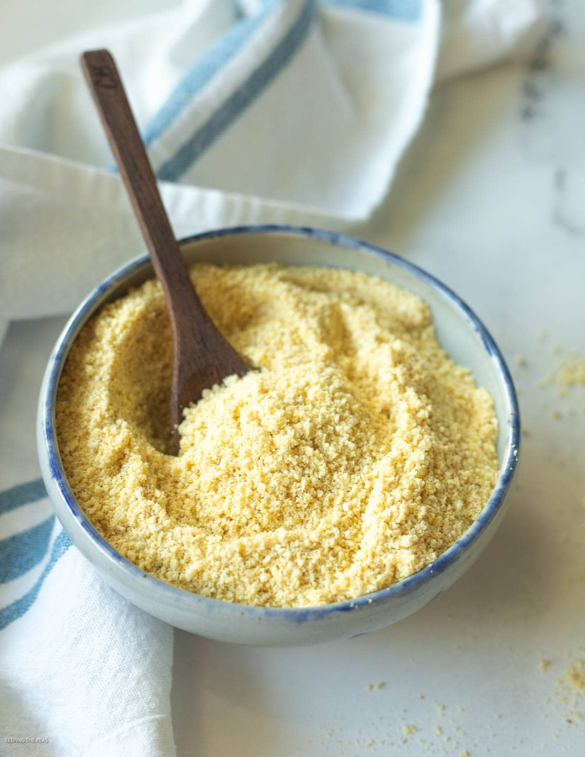Vegan parmesan cheese in a small bowl with a serving spoon.