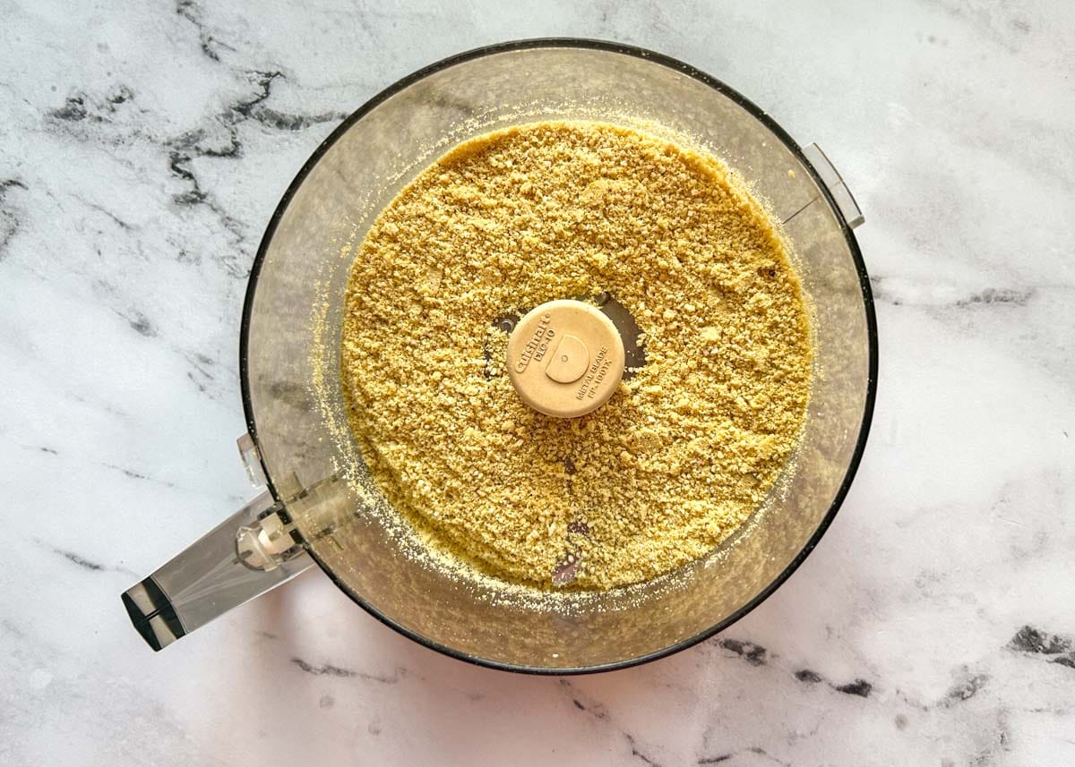 Crumbled cashews and seasoning in food processor.