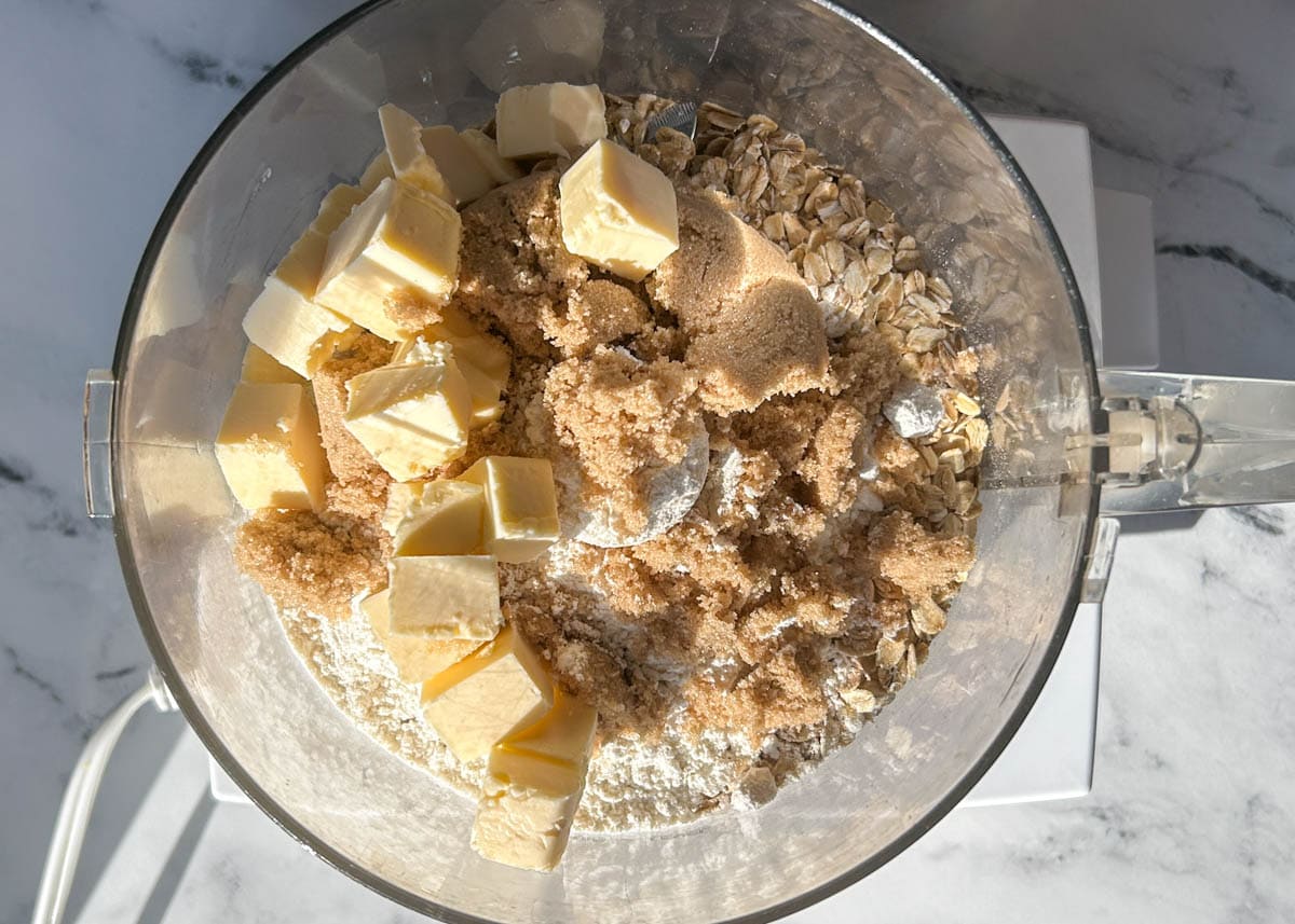 Rolled oats, brown sugar, flour, and vegan butter in food processor.