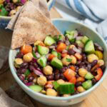Balela sald served with pita wedges in a blue bowl.
