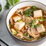 Bowl of miso noodle soup with tofu.