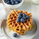 Stack of vegan protein waffles topped with blueberries.